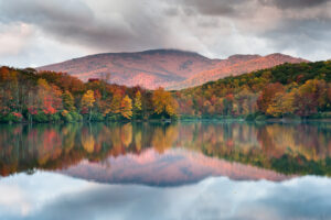 a beautiful lake near Elk River club during fall. the mountains are reflected off of the lake's surface